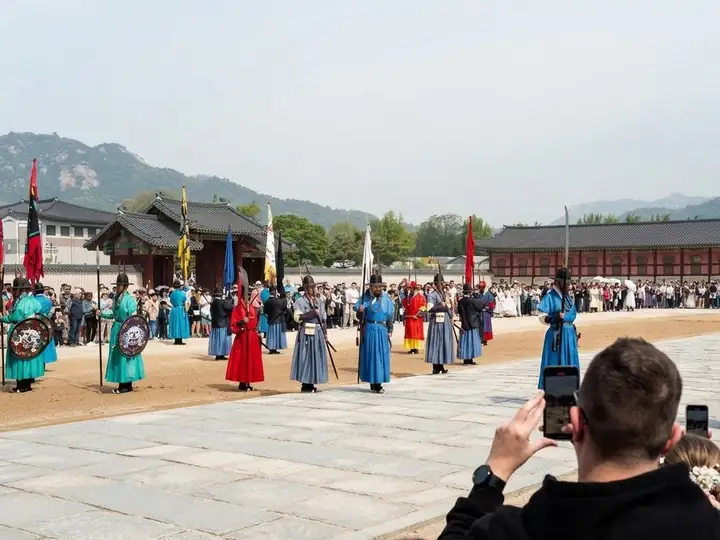 Visitors filming the royal guard ceremony at Gyeongbokgung Palace on their phones