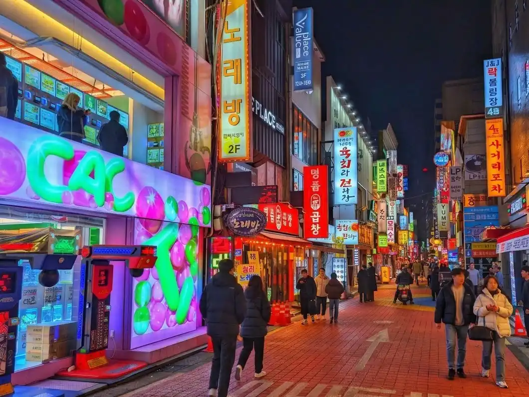 A neon-lit shopping street in Seoul at night